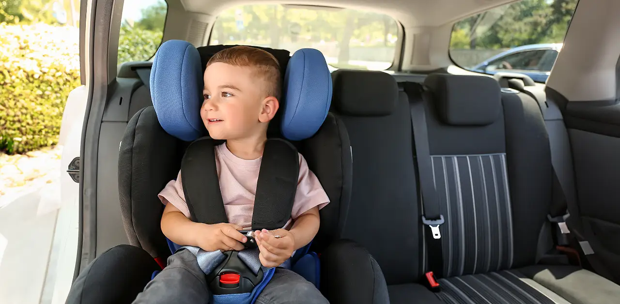child sitting on booster seat in car