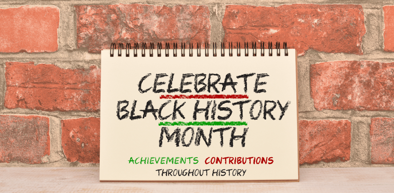 A display of a notepad with the words 'Celebrate Black History Month' against a brick wall.