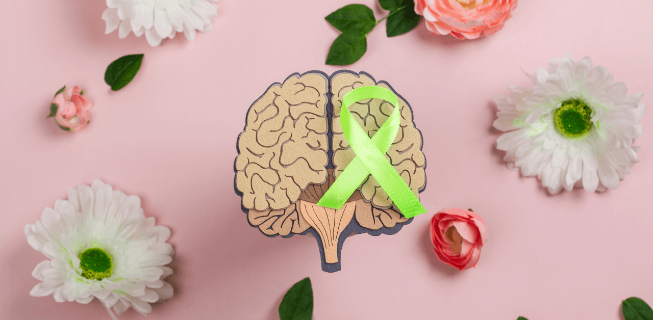 A ribbon symbolizing mental health awareness surrounded by flowers.