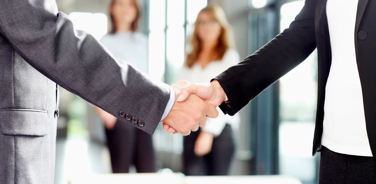 two_business_professionals_shaking_hands_in_an_office_setting
