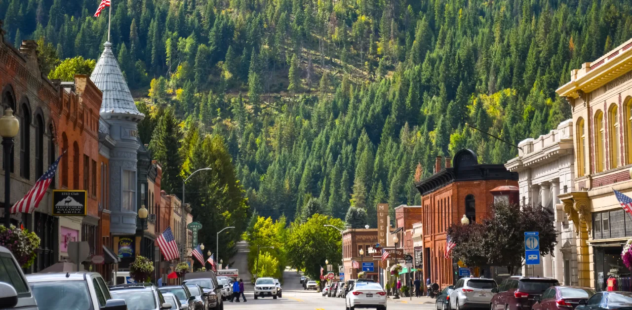 Cars line a small Idaho town street, nestled against the mountains.