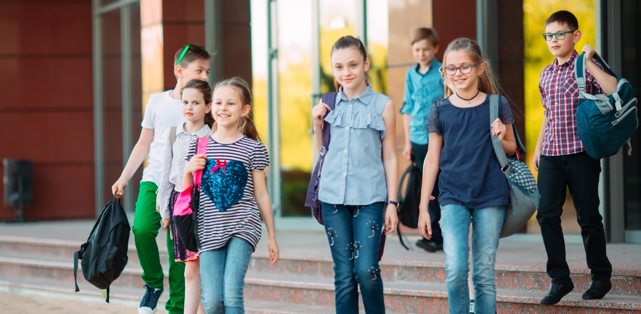 Students leaving school together with backpacks