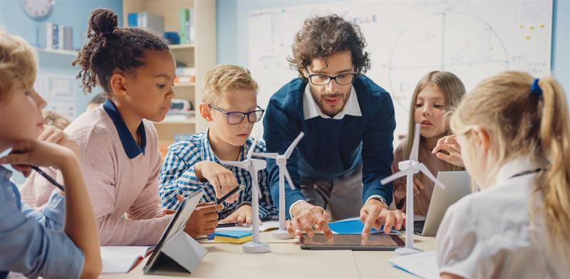 Teacher working with young students on a hands-on classroom activity