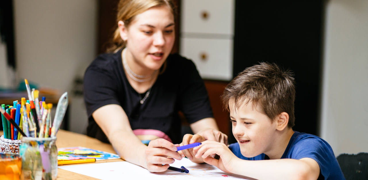 teacher assisting a student during a classroom activity