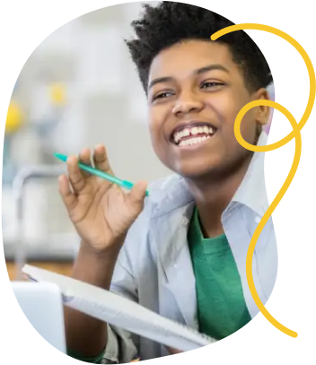Two students smile while working with a teacher on a project in a classroom.