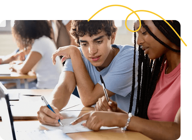 Two students sitting at a desk, collaborating on paperwork. They appear focused and engaged. Text below reads: "Students Experiencing Housing Instability."