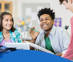Two students smile while working with a teacher on a project in a classroom. The text reads, "Students with Out-of-District Placements."