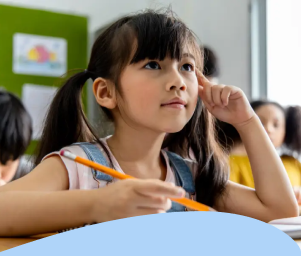 A young girl with a ponytail attentively listens in class, holding a pencil. Behind her, students engage in learning. Text: