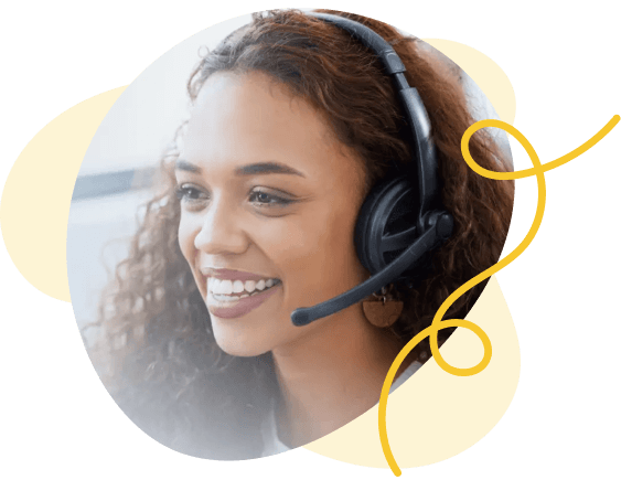 A customer support specialist with a headset talks on the phone while smiling.