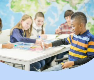 Children studying together at a table with a globe in a classroom.